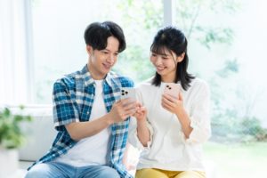 スマホで情報収集する若い男女