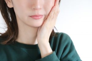 頬に手をあてている若い女性
