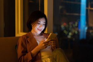 夜スマホを触る女性
